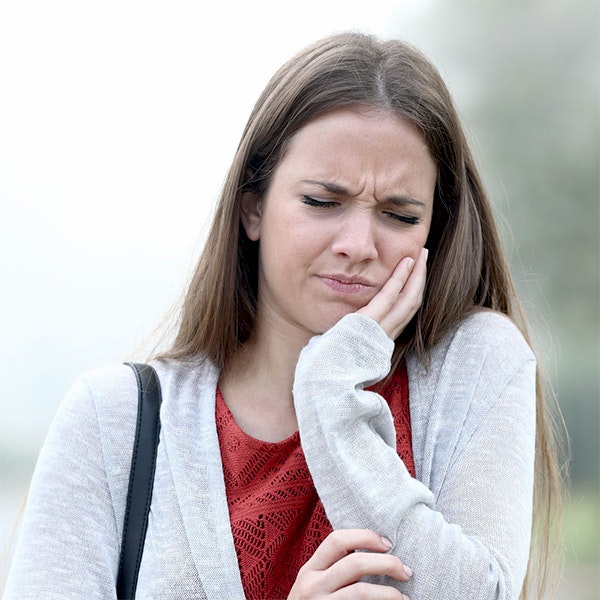 Woman with hand on jaw